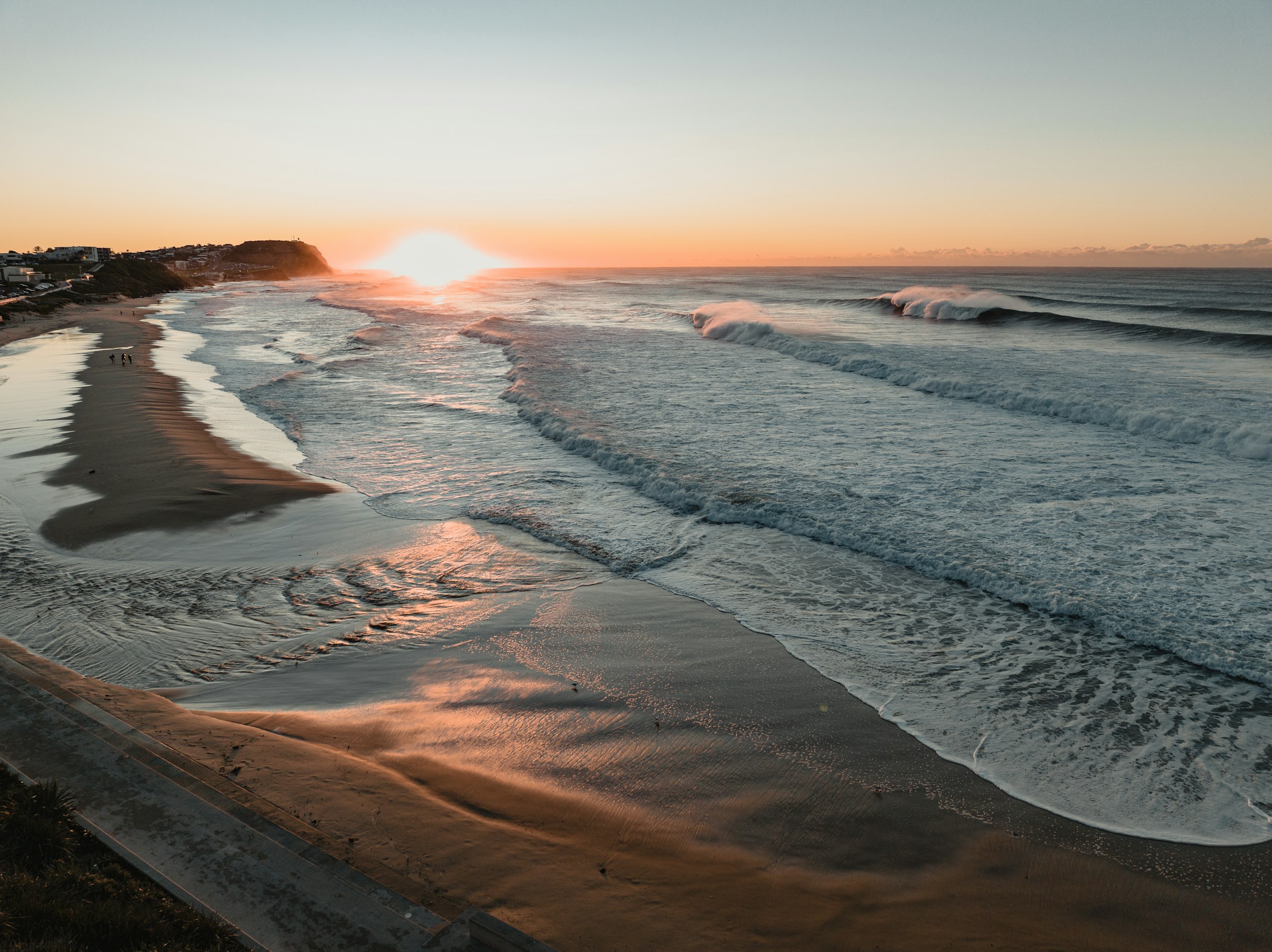 A calm ocean shoreline at sunrise